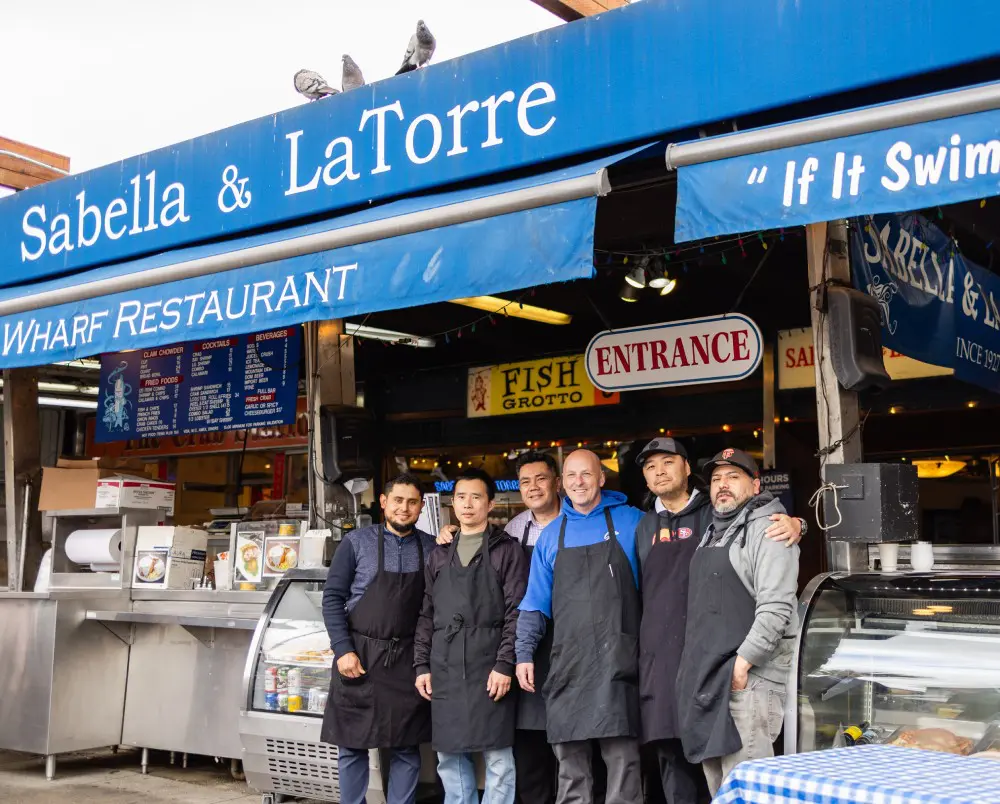 A group of men standing in front of a restaurant.