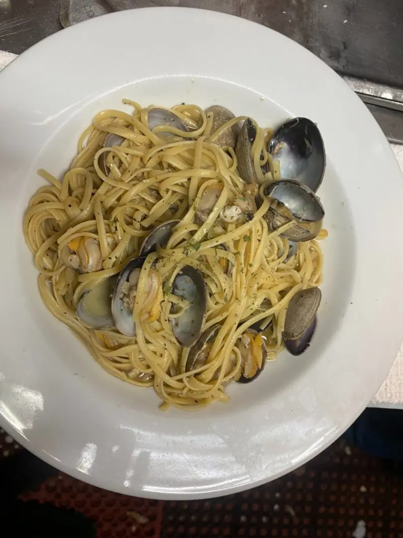 A plate of pasta with clams on top.