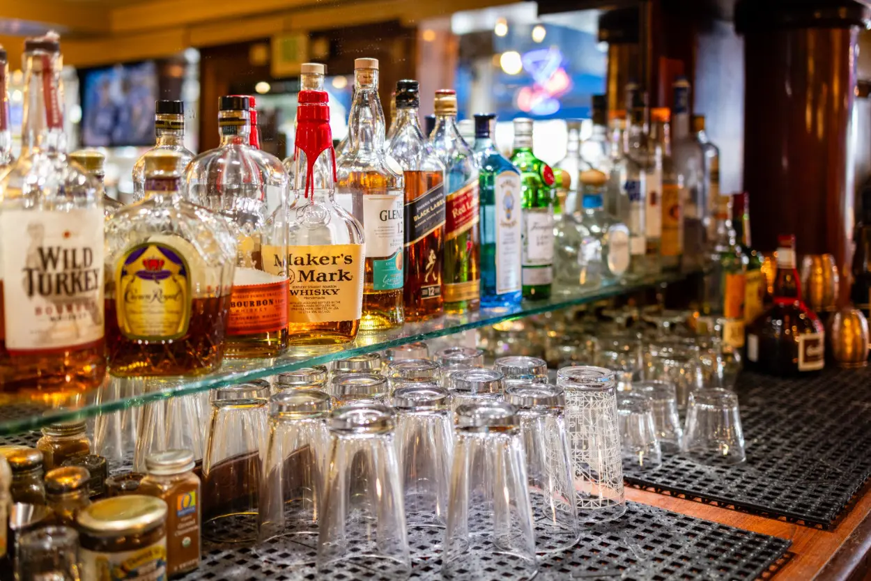 A bar with many glasses and bottles of alcohol.