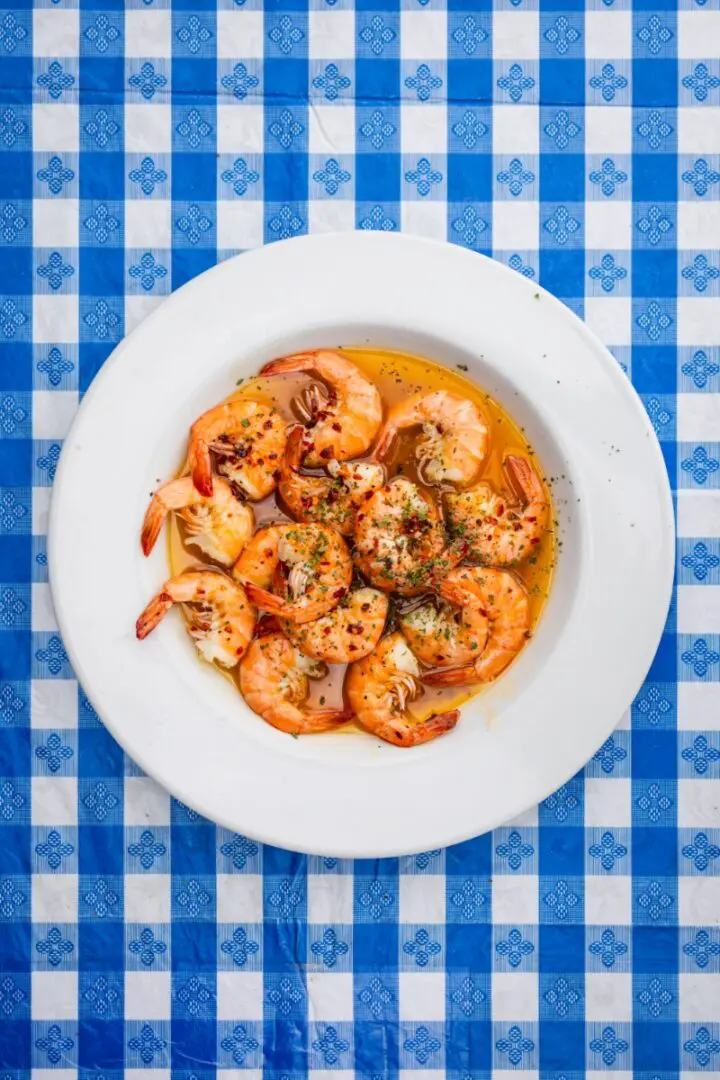 A white plate topped with shrimp covered in sauce.