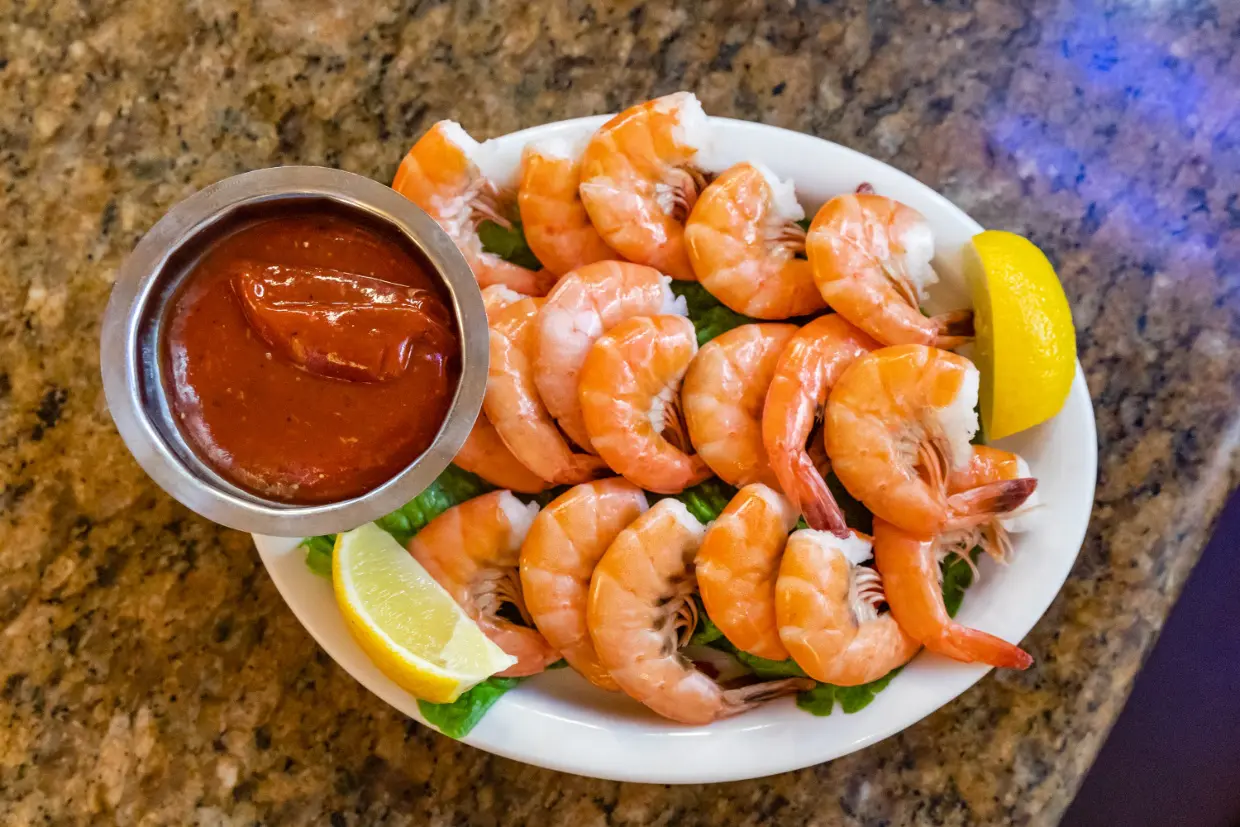 A plate of shrimp and sauce on the table.